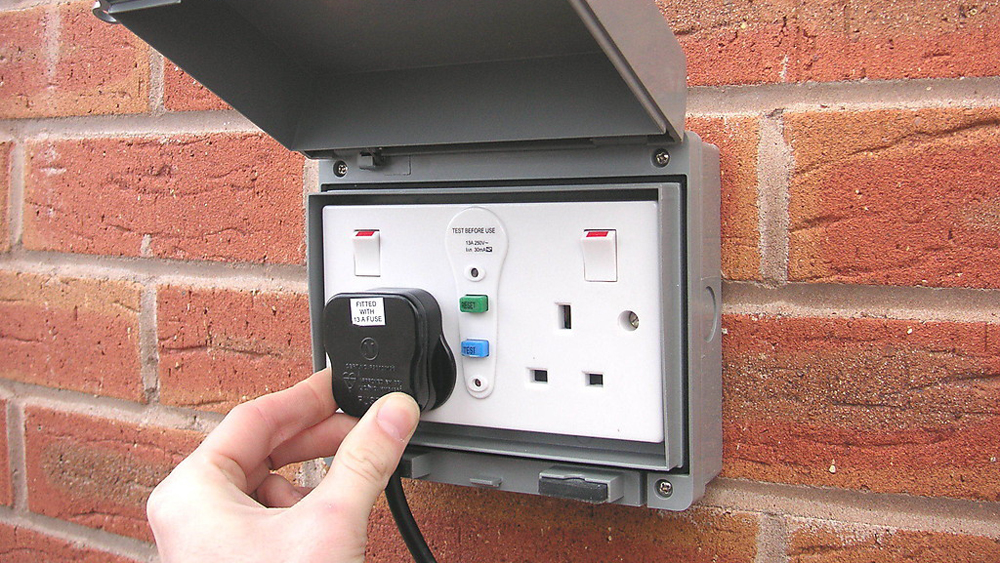 Outdoor socket installation in London on exterior brick wall - weatherproof socket